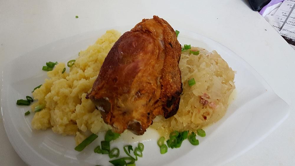 Ein Teller mit Kartoffelbrei und Fleisch auf einem Tisch.