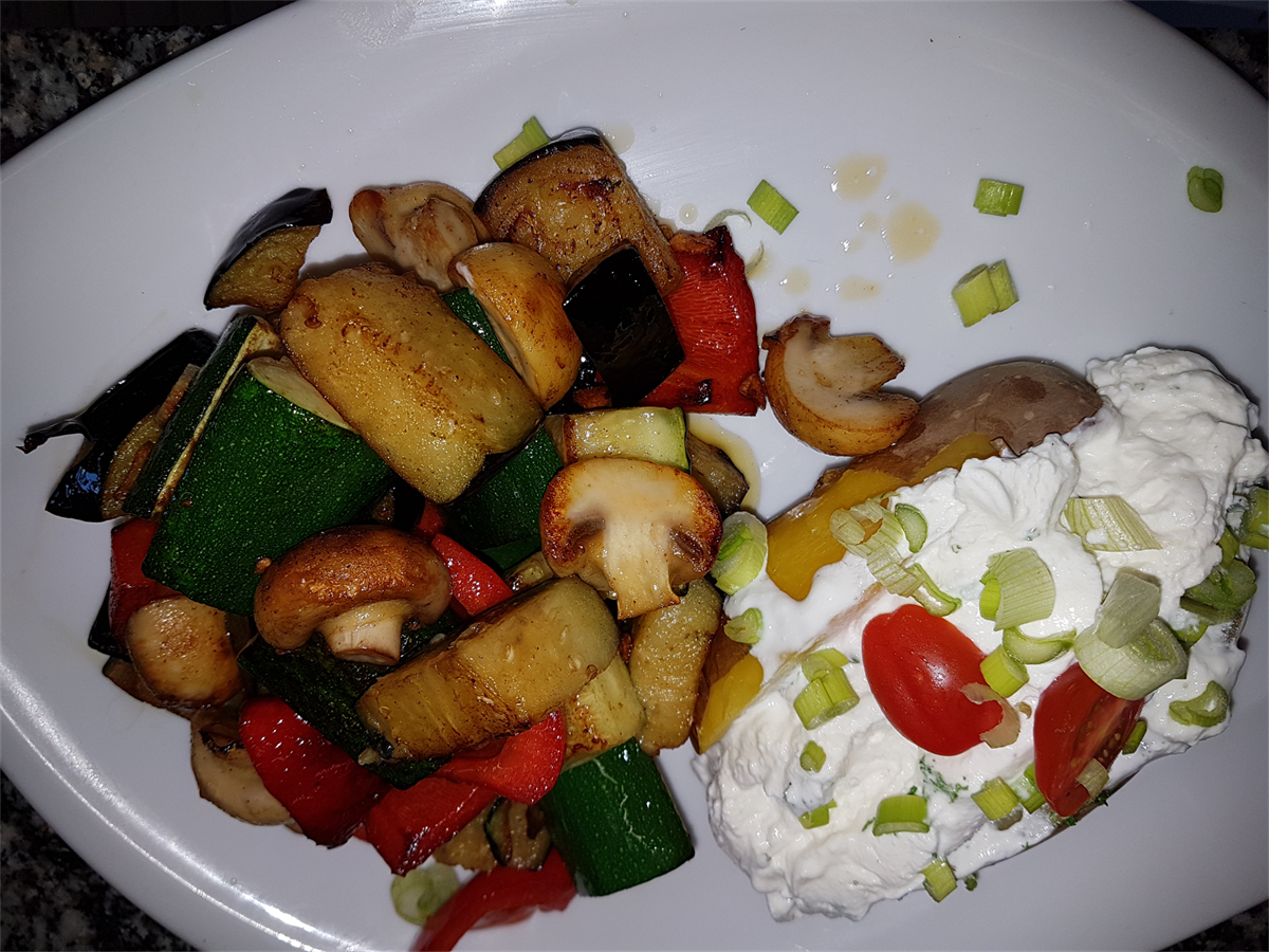 Ein weißer Teller mit Gemüse und saurer Sahne