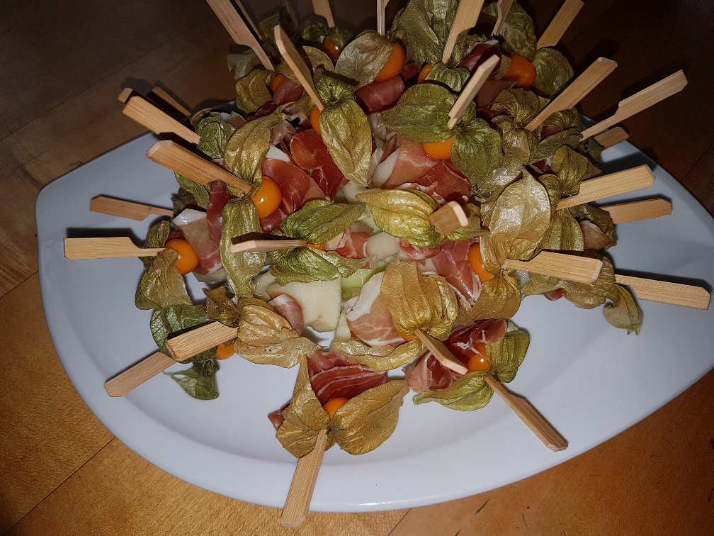 Ein weißer Teller mit einem Salat am Spieß