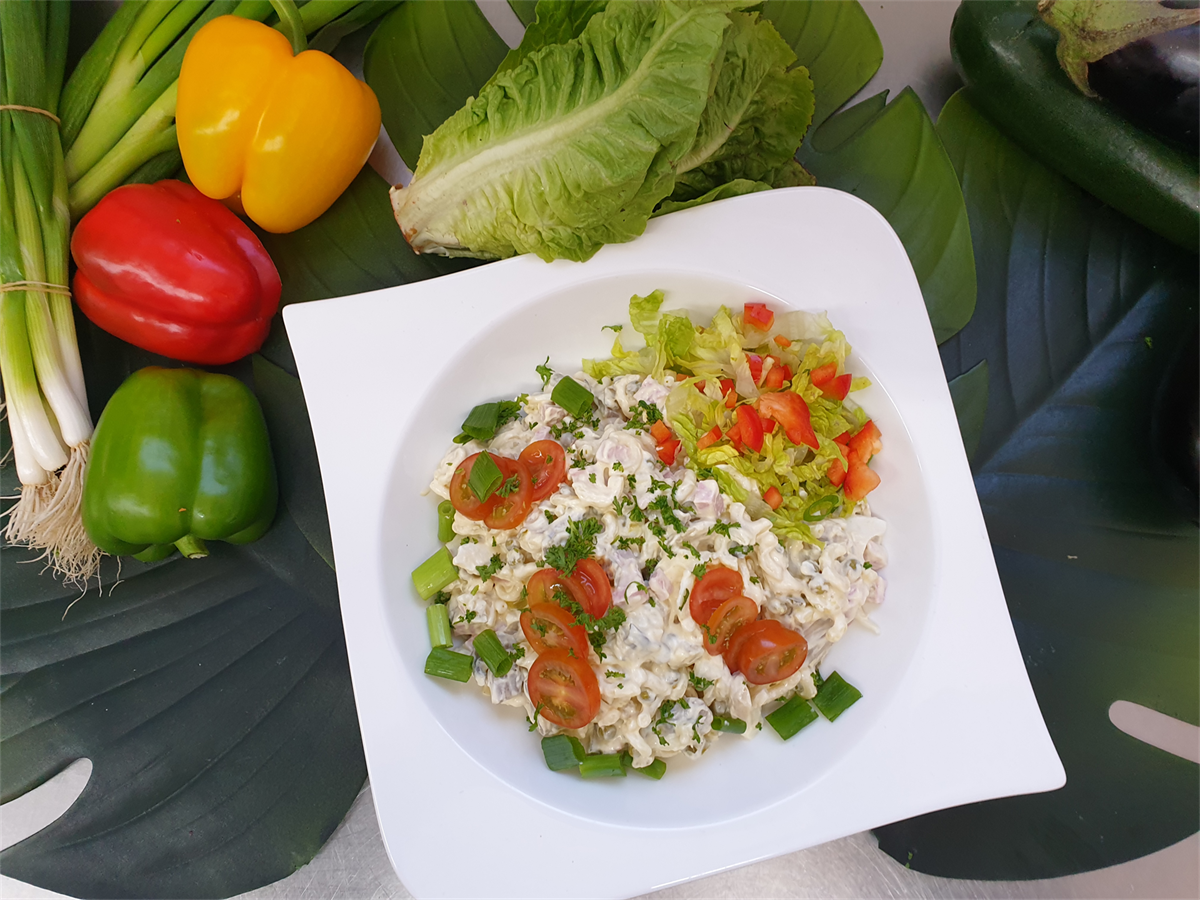 Eine Schüssel mit Essen ist von Gemüse auf einem Tisch umgeben