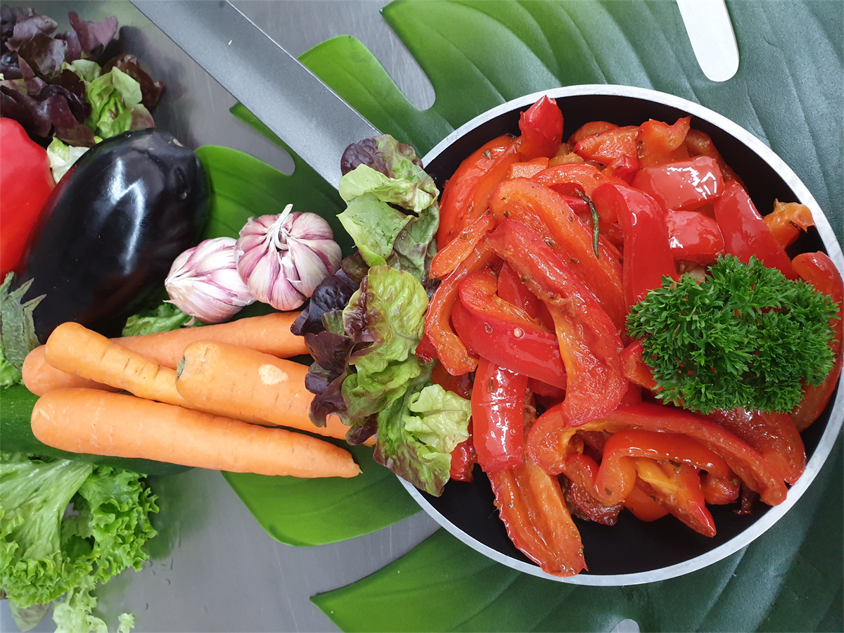 Eine Pfanne gefüllt mit Gemüse, darunter Karotten und Paprika