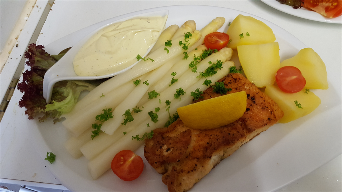 Ein Teller mit Spargel, Kartoffeln und Tomaten