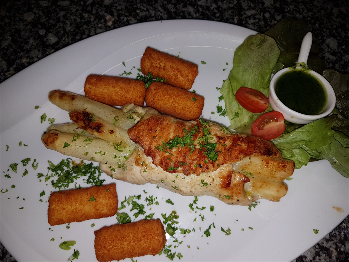 Ein Teller mit Essen mit Spargel und Croutons darauf