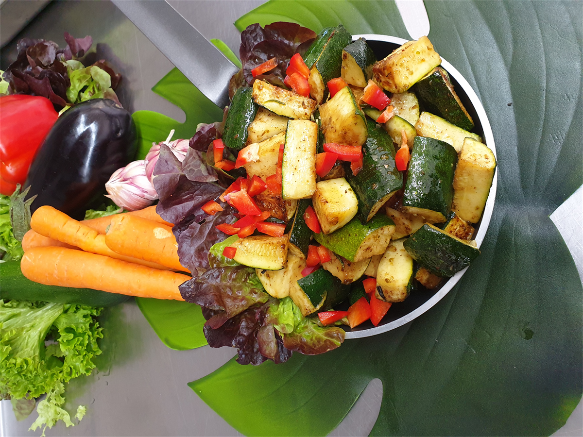 Eine Pfanne gefüllt mit Gemüse, darunter Karotten und Zucchini