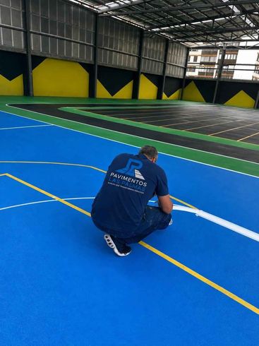 Persona agachada en una cancha deportiva cubierta