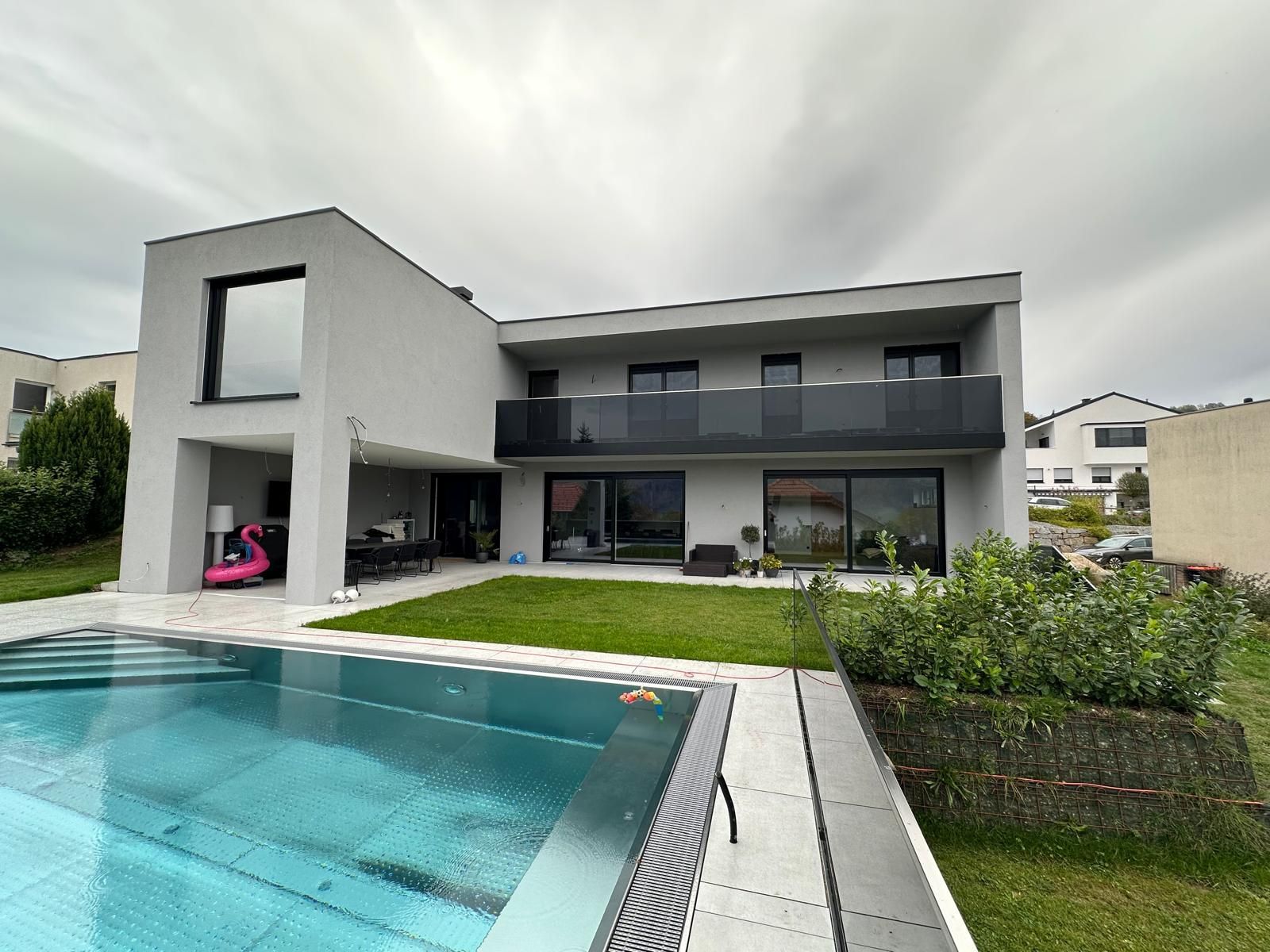 Ein großes Haus mit einem Swimmingpool davor.