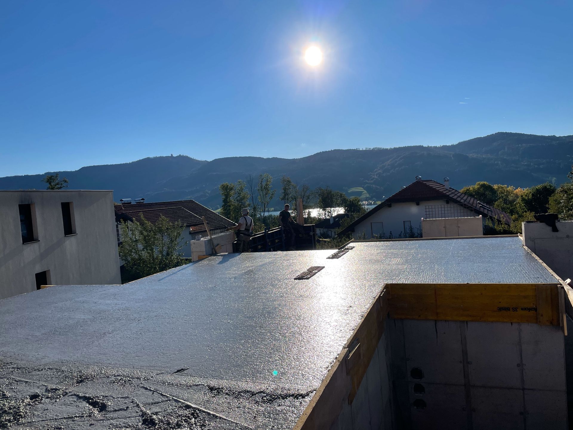 Die Sonne scheint hell auf das Dach eines im Bau befindlichen Gebäudes.