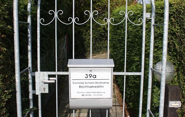 Ein Metalltor mit einem Briefkasten davor, auf dem 39a steht