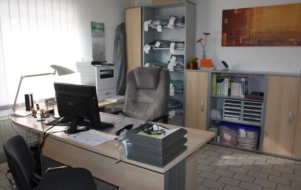 Ein Schreibtisch mit einem Computer und einem Stuhl in einem Büro