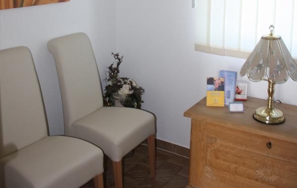 Ein Wartezimmer mit zwei Stühlen und einer Lampe