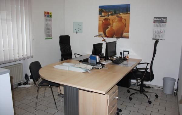 Ein Zimmer mit einem Schreibtisch und Stühlen und einem Gemälde an der Wand