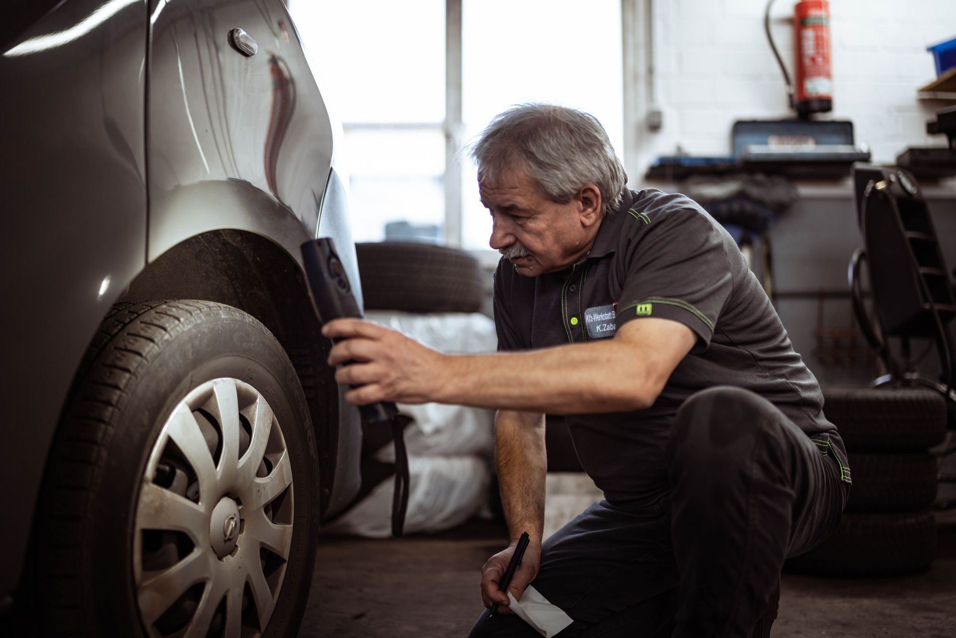Ein Mann arbeitet in einer Garage an einem Auto.