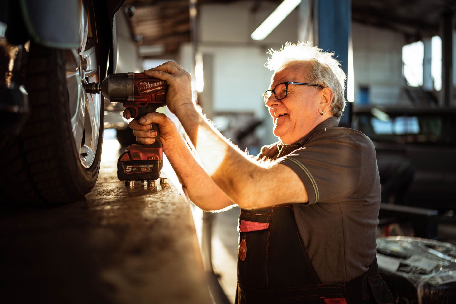 Ein Mitarbeiter arbeitet in einer Garage an einem Auto.