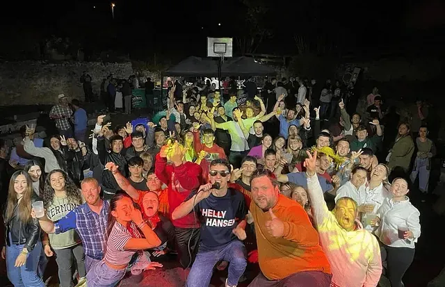 Un grupo grande de personas posa para una fotografía en una fiesta.