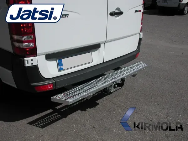 Valkoinen pakettiauto, jossa on metallinen taka-askelma, pysäköitynä asfaltille