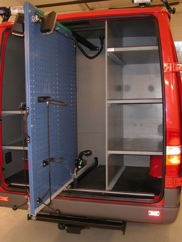 Avoin takaperän pakettiauto, jossa on sininen rei'itetty tavaraverhoilu ja hyllyt sisällä