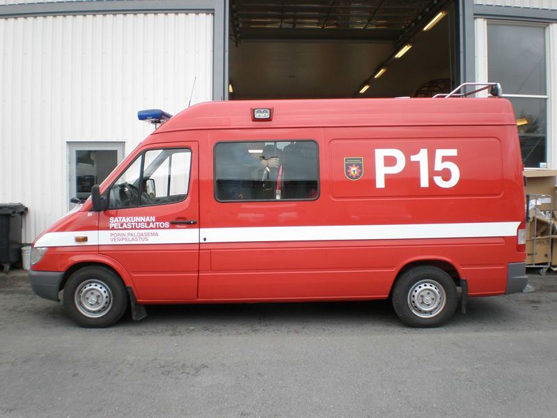 Punainen paloauto, jossa on merkintä ”P15”, pysäköitynä autotallin ulkopuolelle