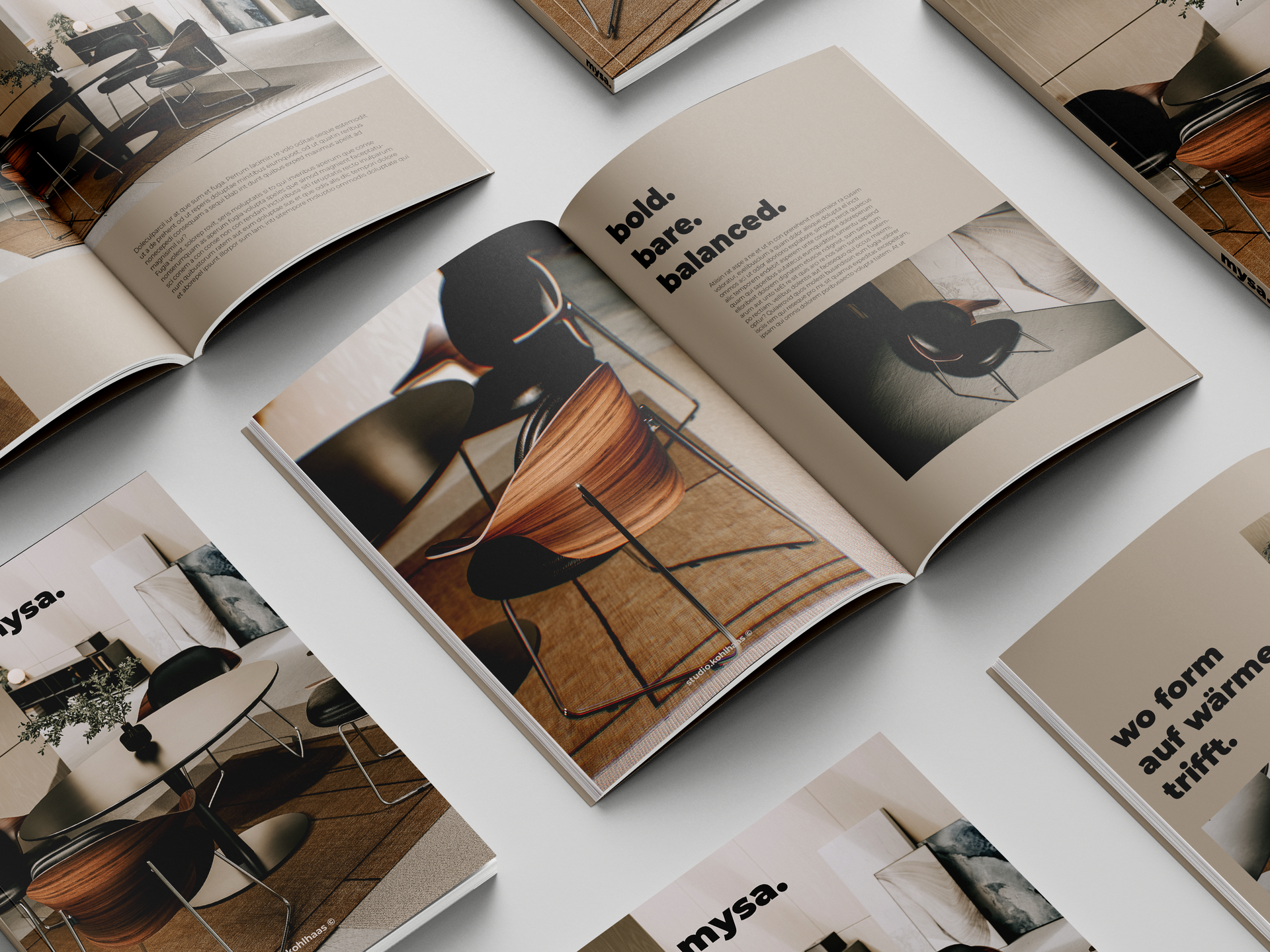 Offene Broschüren mit Möbelfotos und Text, angeordnet auf einer hellen Oberfläche.