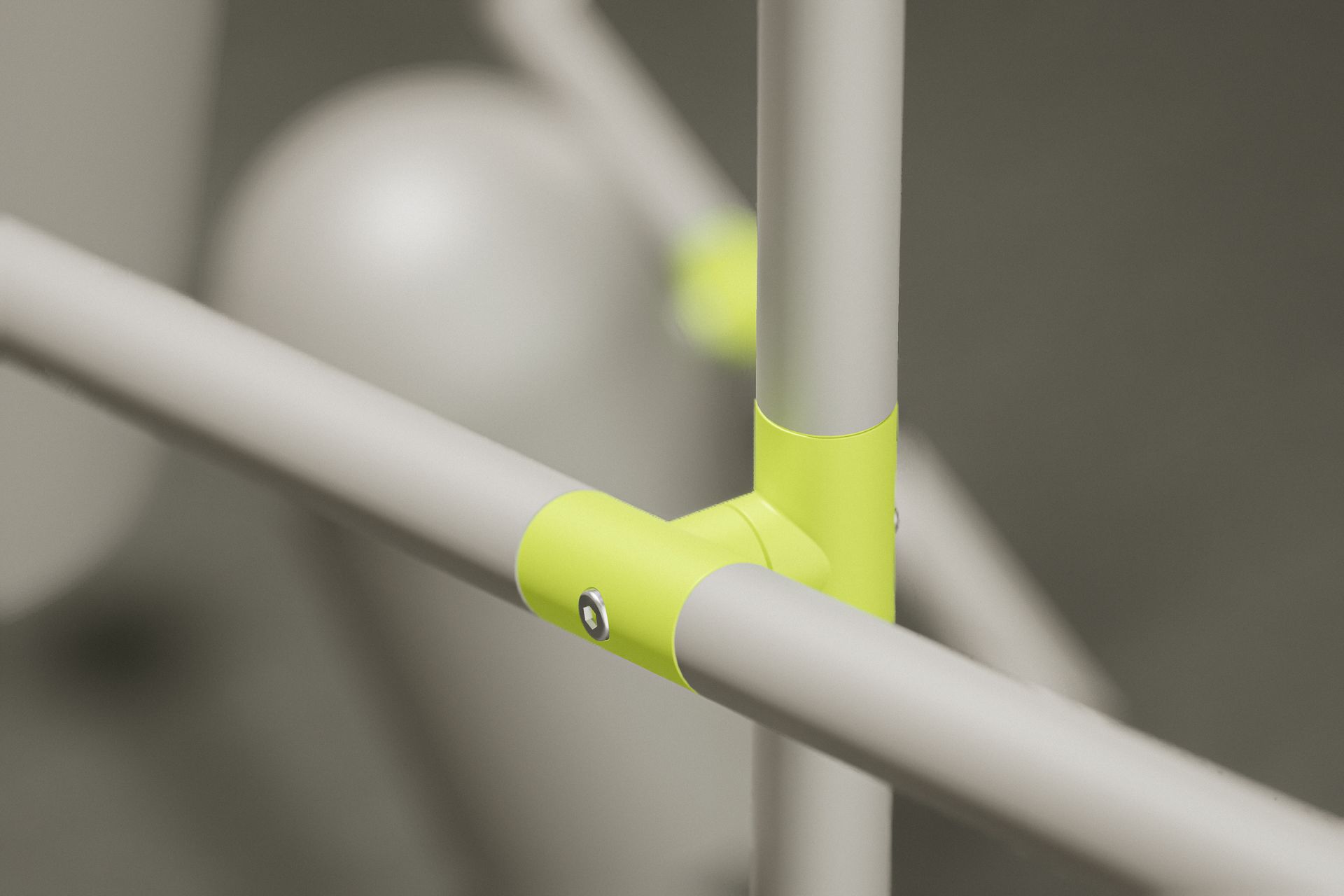 Gelenkdetail einer modernen Pendelleucht in Grau mit Gelben Akzenten, Detailaufnahme.