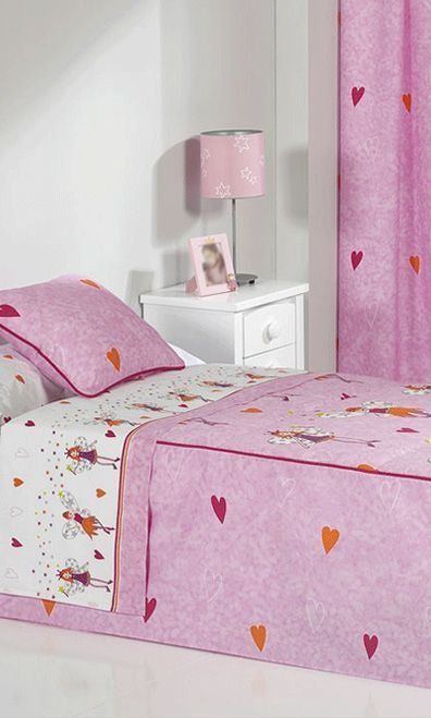 Una cama con un edredón rosa y almohadas en un dormitorio.