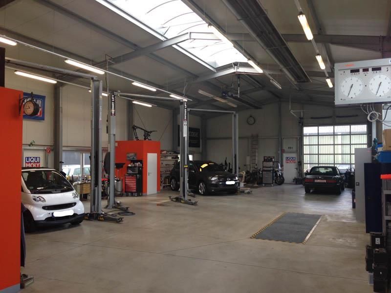 Eine Garage mit Autos auf Hebebühnen und einem Schild mit der Aufschrift 