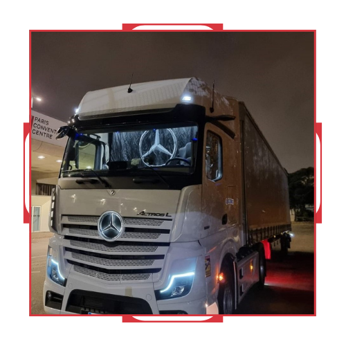 Un camión Mercedes está estacionado en un estacionamiento por la noche.