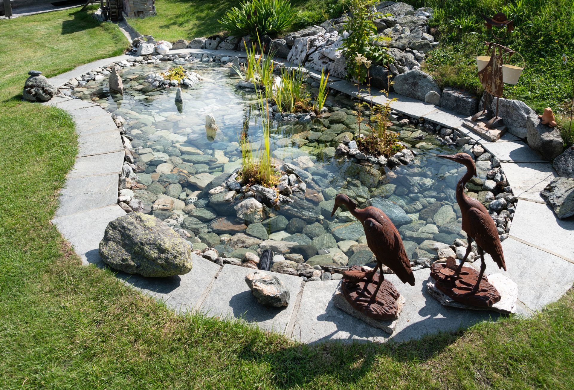Bassin dans un jardin avec un fond en pierres