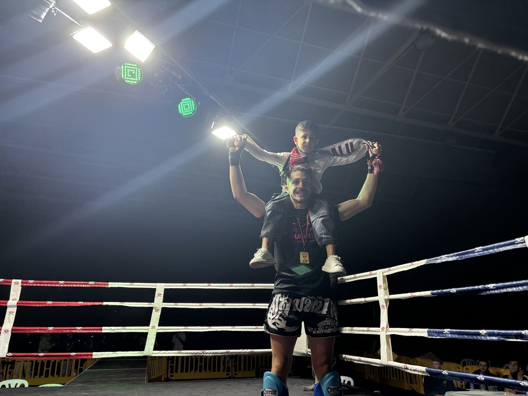 Boxeador practicando golpes con un entrenador en un ring de boxeo.