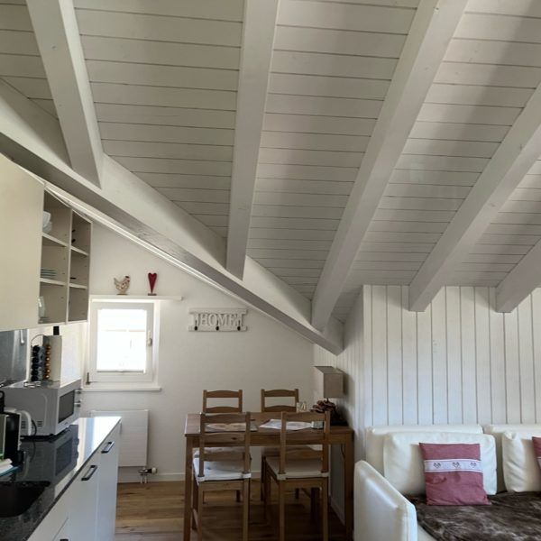 Ein Wohnzimmer mit einem Tisch und Stühlen. Foto von der Witschi Malerei.