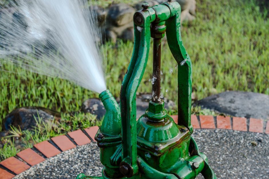 Bomba de agua verde rociando agua al aire libre.