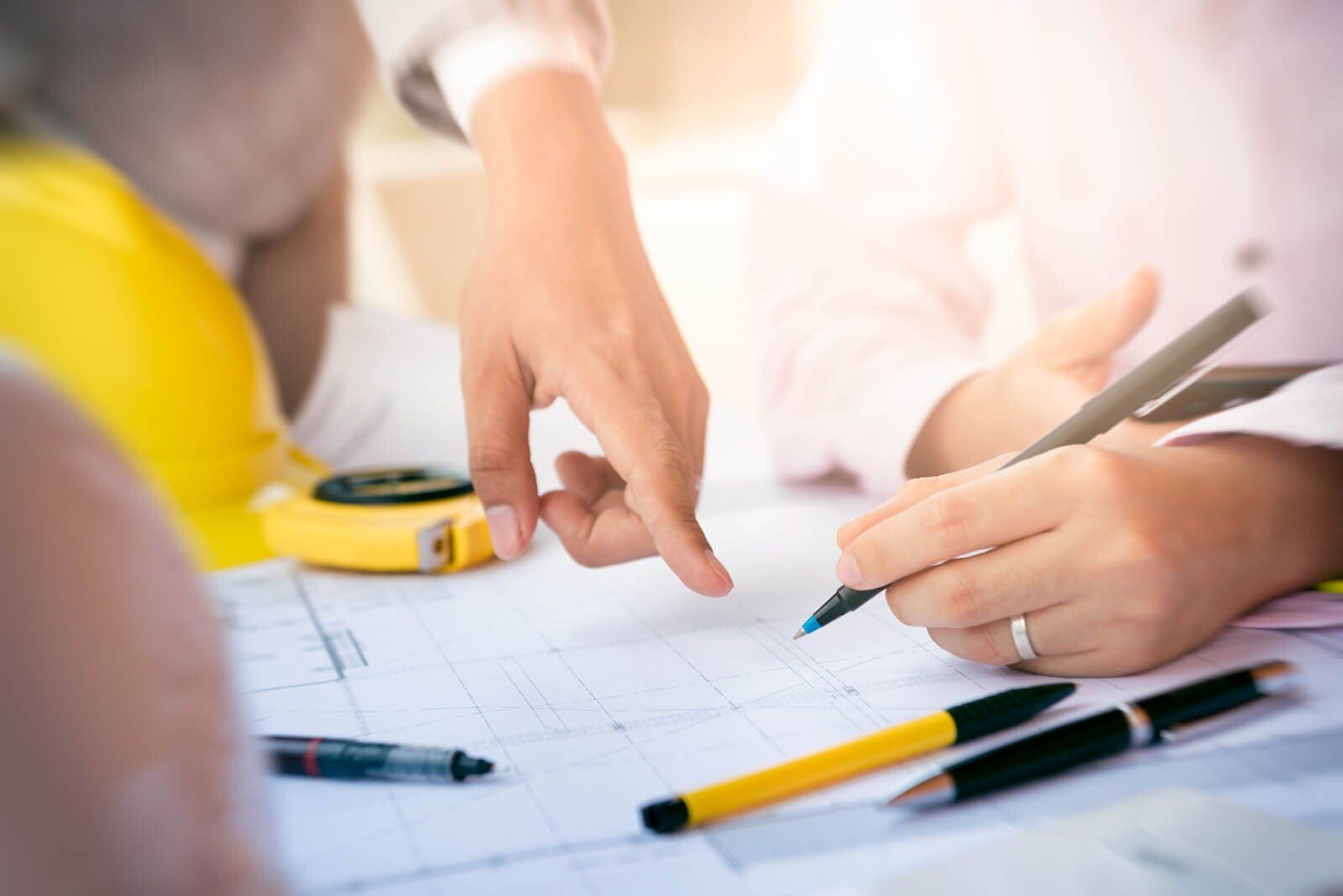 Deux personnes écrivant sur un plan de construction