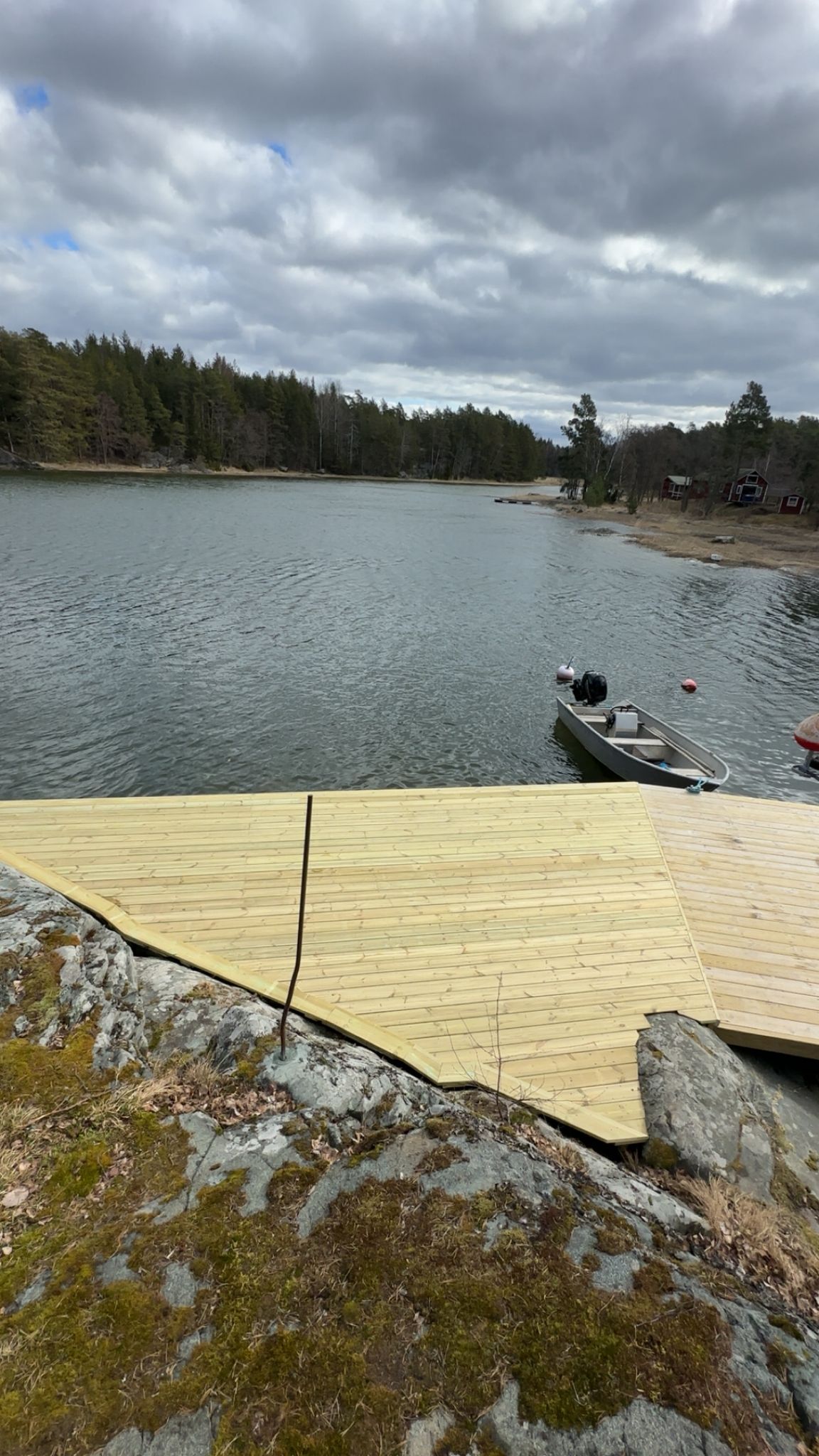 Uusi tukeva venelaituri ja uimataso asennettuna mökkirantaan Porvoon Pellingissä.