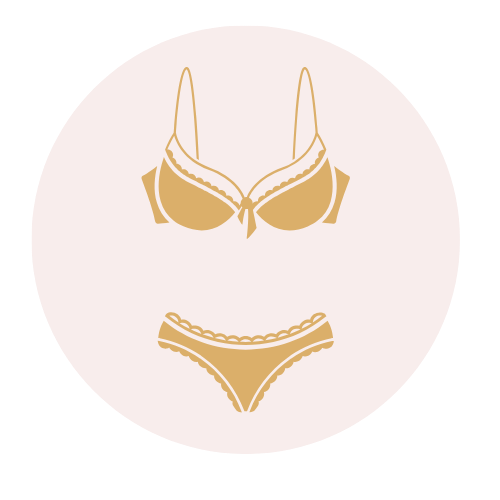 Conjunto de sujetador y ropa interior dorado sobre fondo rosa pálido.