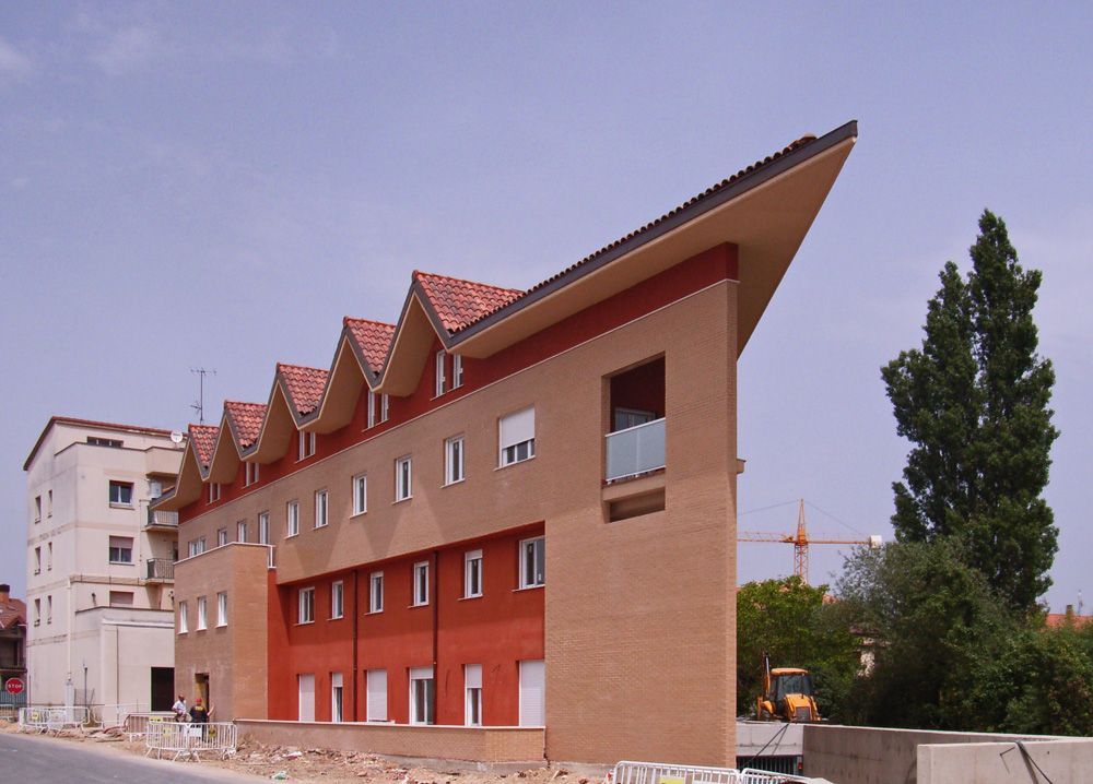 Un gran edificio de ladrillo con techo de tejas rojas.