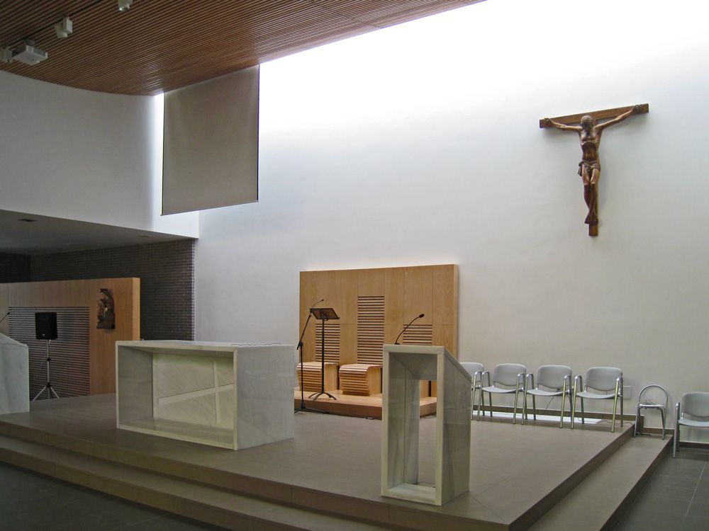 Una iglesia con una cruz en la pared sobre el altar