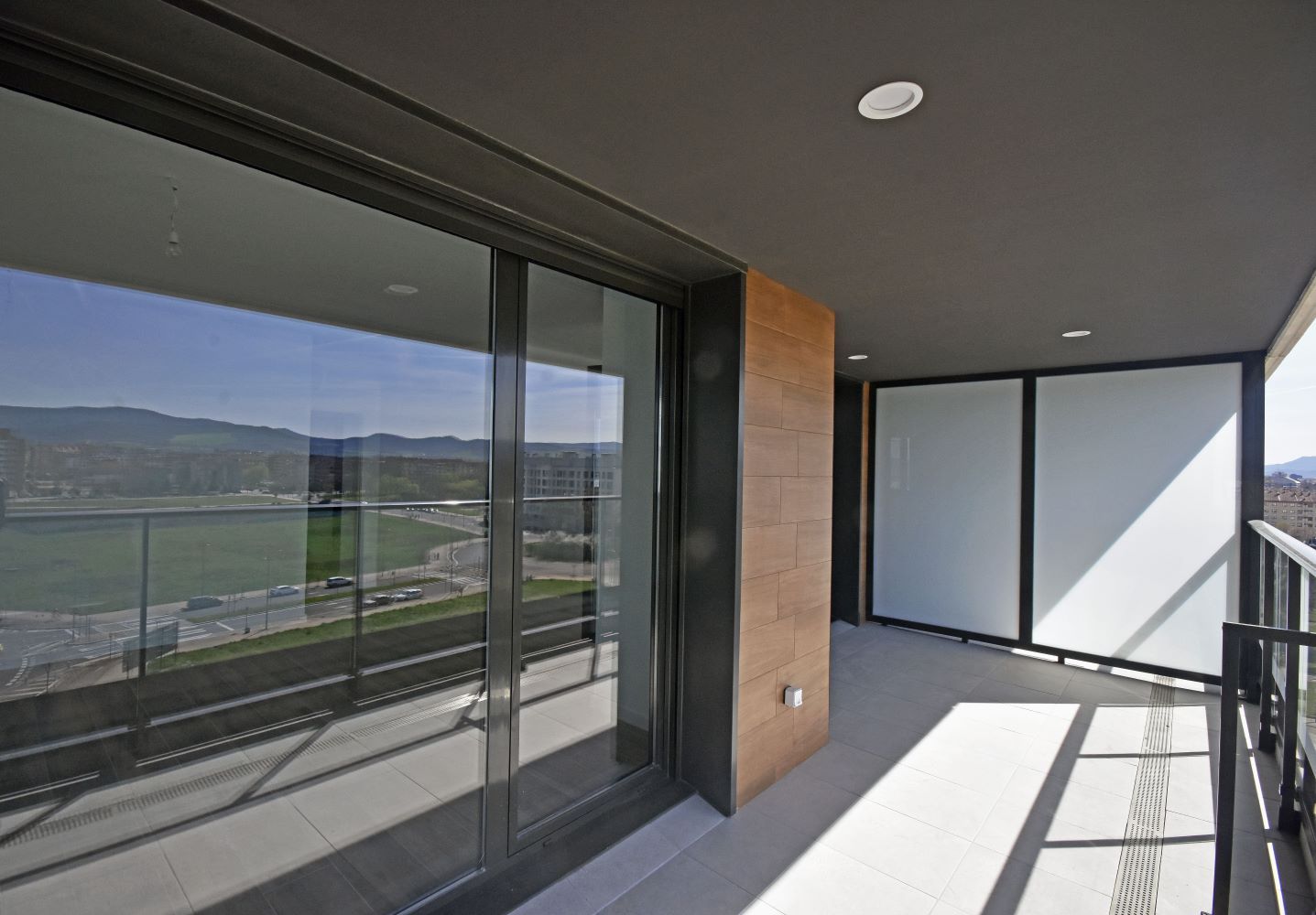 Un balcón con vista a un campo y montañas.