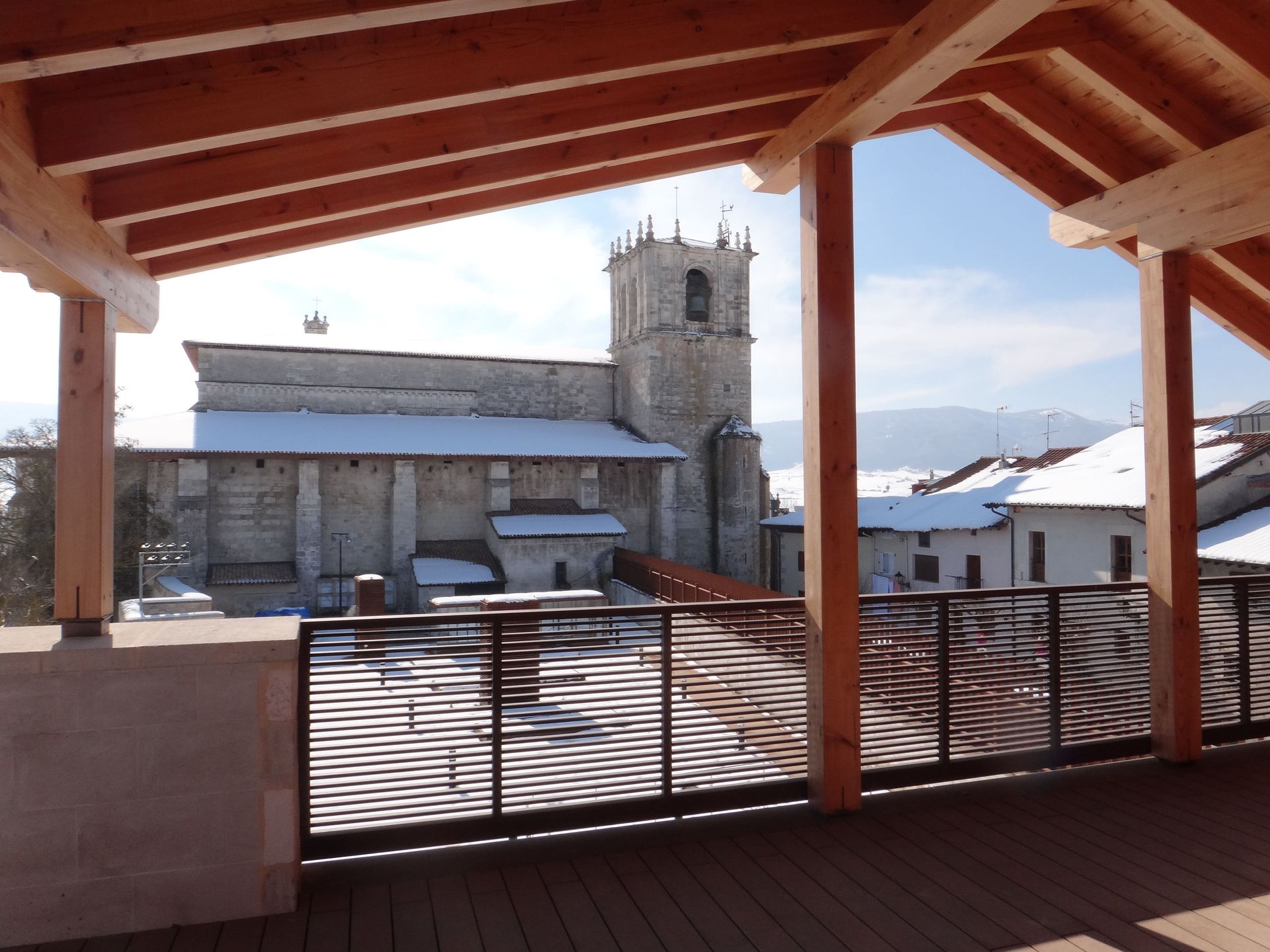 Un balcón con vista a una iglesia al fondo.