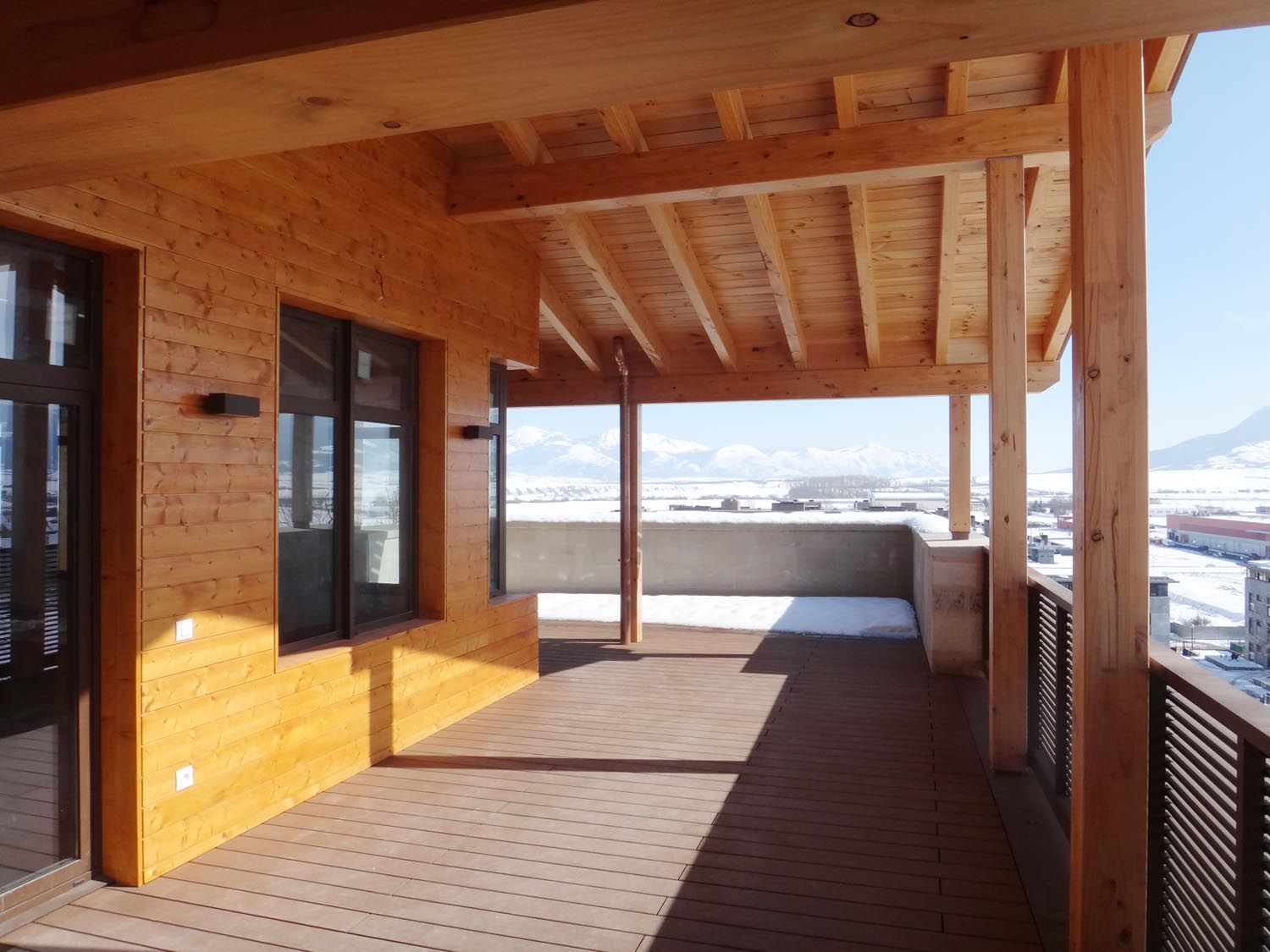 Un balcón de madera con vista a las montañas.