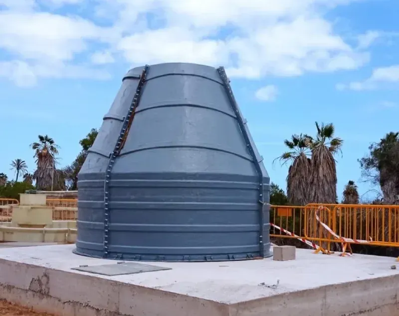 Conducto de ventilación de metal gris en la azotea, sobre una plataforma de hormigón