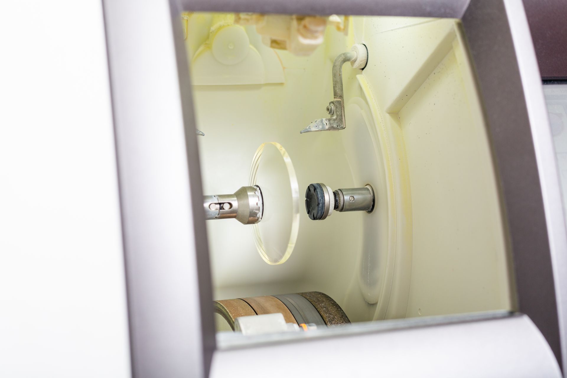 Gros plan sur l'intérieur d'une machine de couleur crème avec deux connecteurs métalliques et une extrémité de câble enroulée.