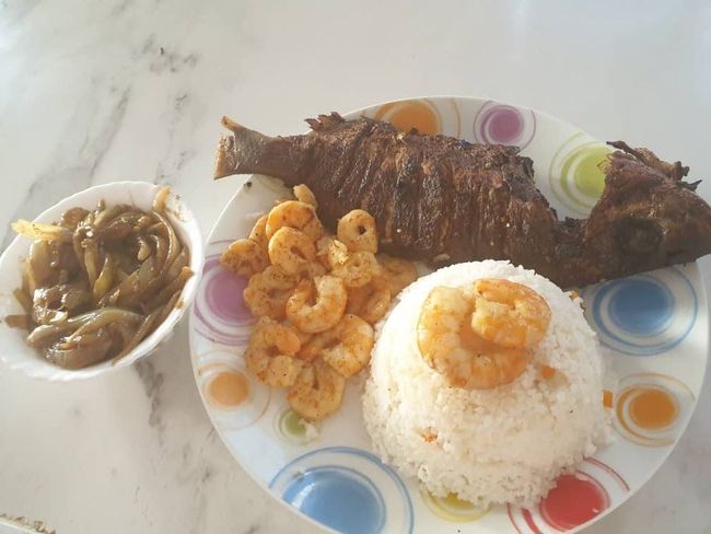 Une assiette de nourriture avec du riz et des crevettes dessus