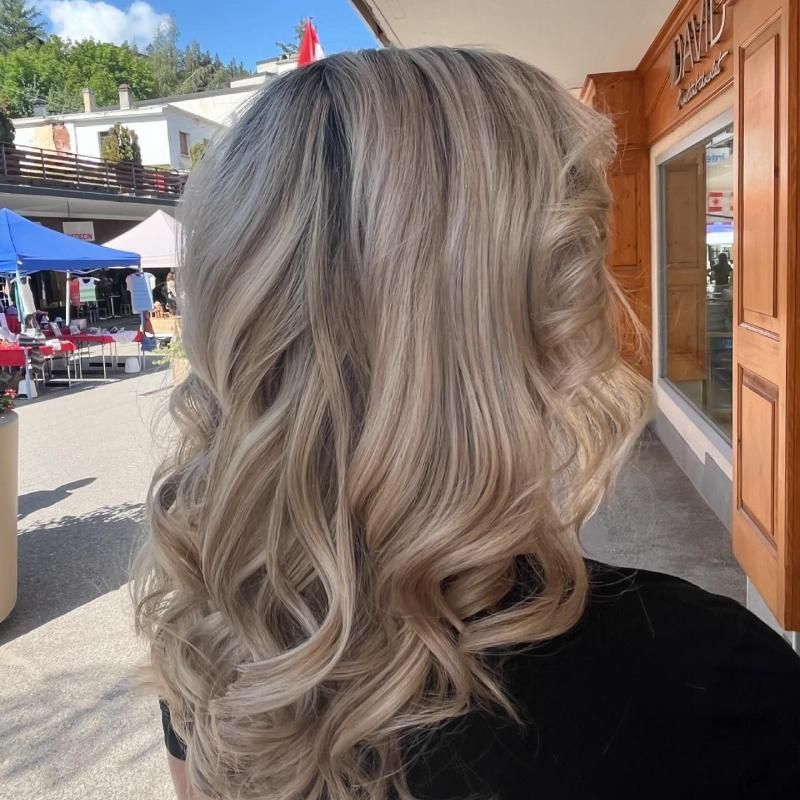 Une femme aux longs cheveux blonds se tient devant un bâtiment sur lequel est écrit privé