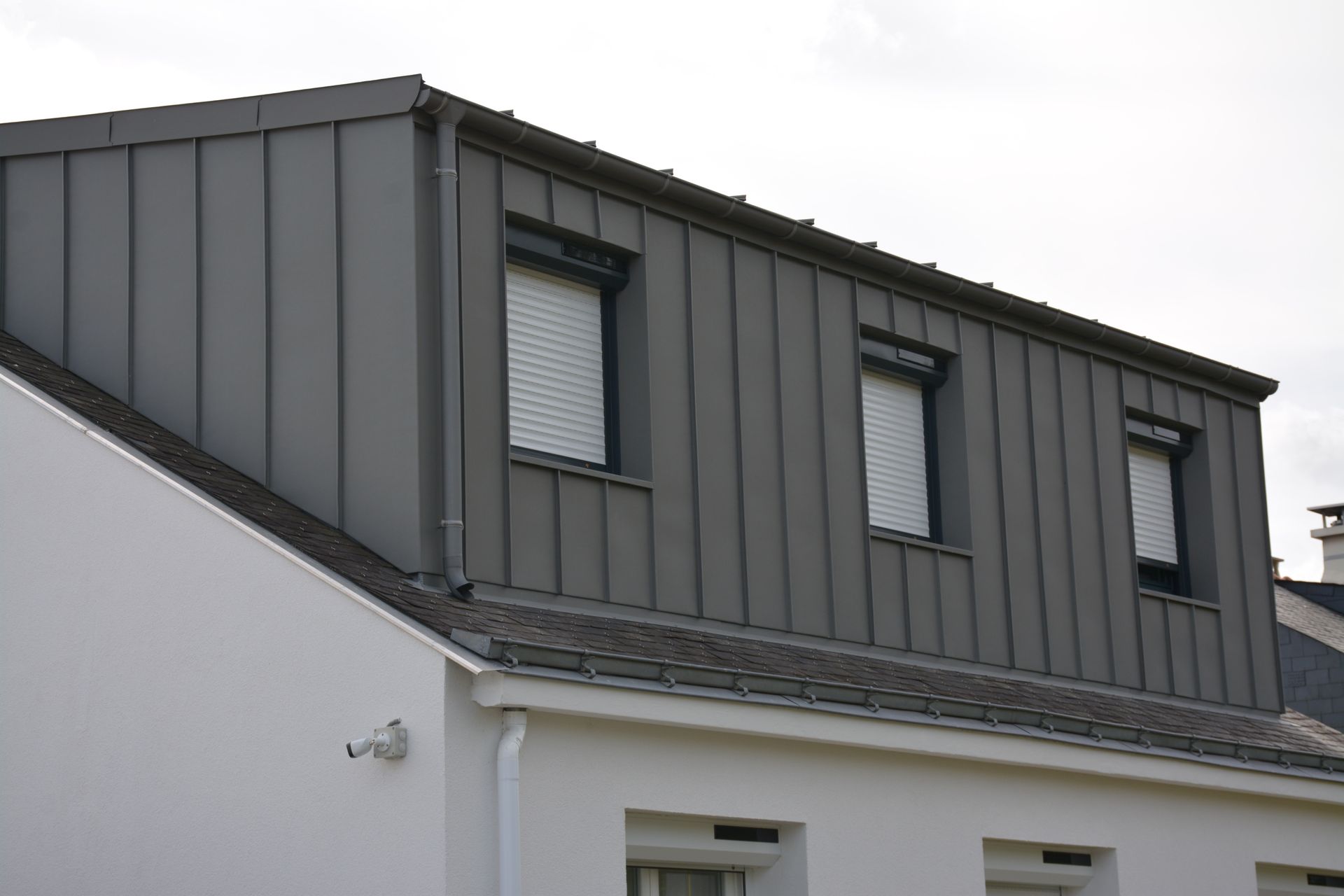 étal gris sur une maison blanche.