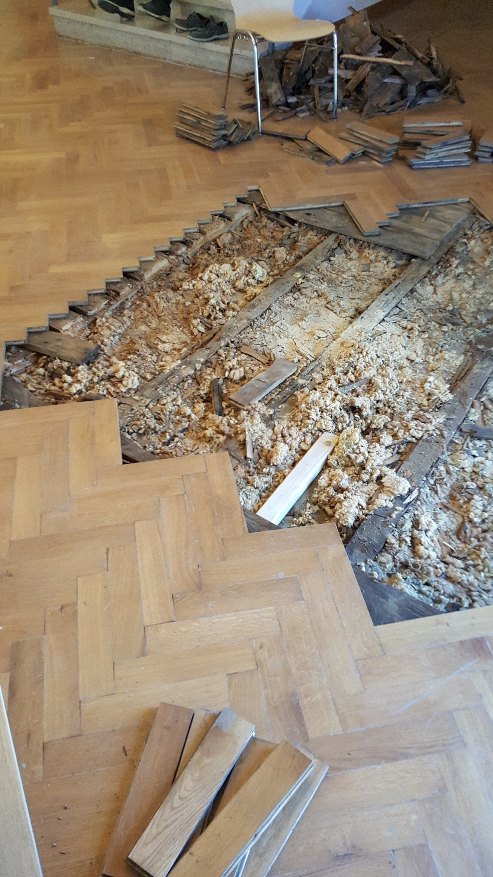 Des plaintes de bois cassées en plusieurs morceaux en dessous d'un parquet
