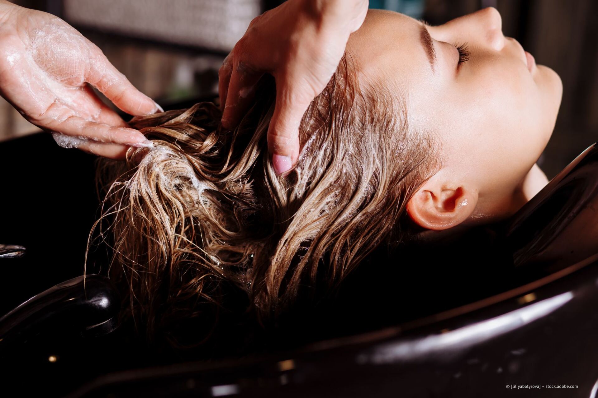 Mitarbeiter von Haarkosmetik Lady & Men wäscht Haare einer Kundin