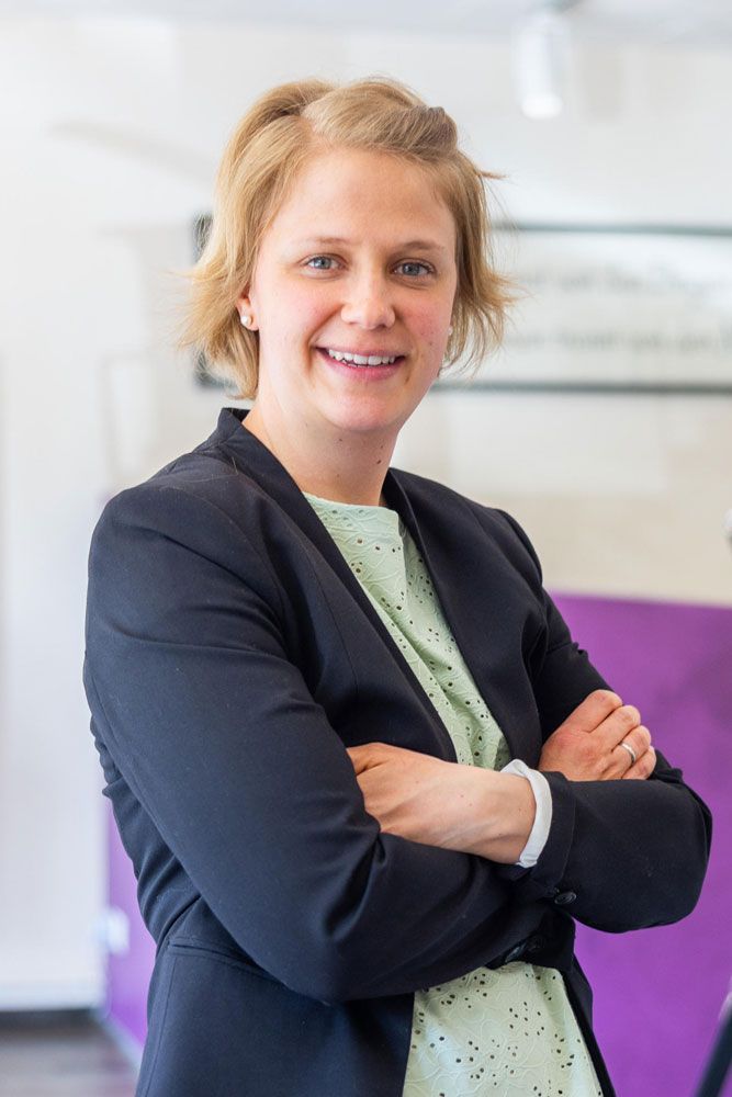 Eine junge Frau lächelt in die Kamera und trägt einen Anzug .