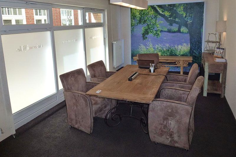 ein Raum mit einem Tisch und Stühlen und einer Wand mit einem Baum darauf