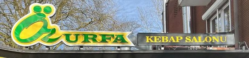 Schild für „Urfa Kebap Salonu“ in Grün und Gelb.