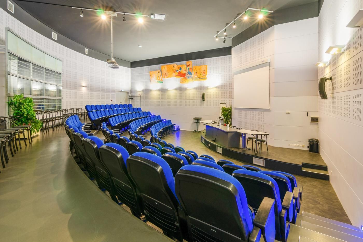 Un amphi avec une rangée de chaises bleues.