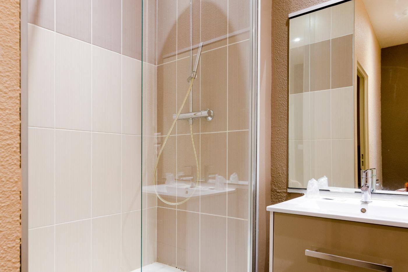 Une salle de bain avec douche et lavabo.